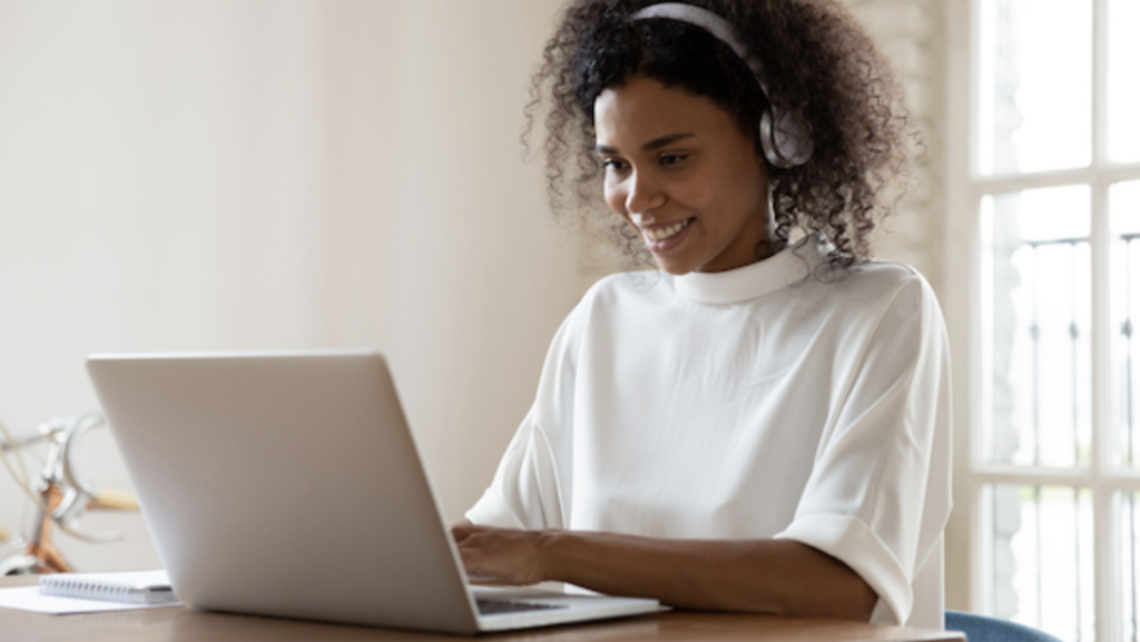 A women wearing headphone working on a laptop